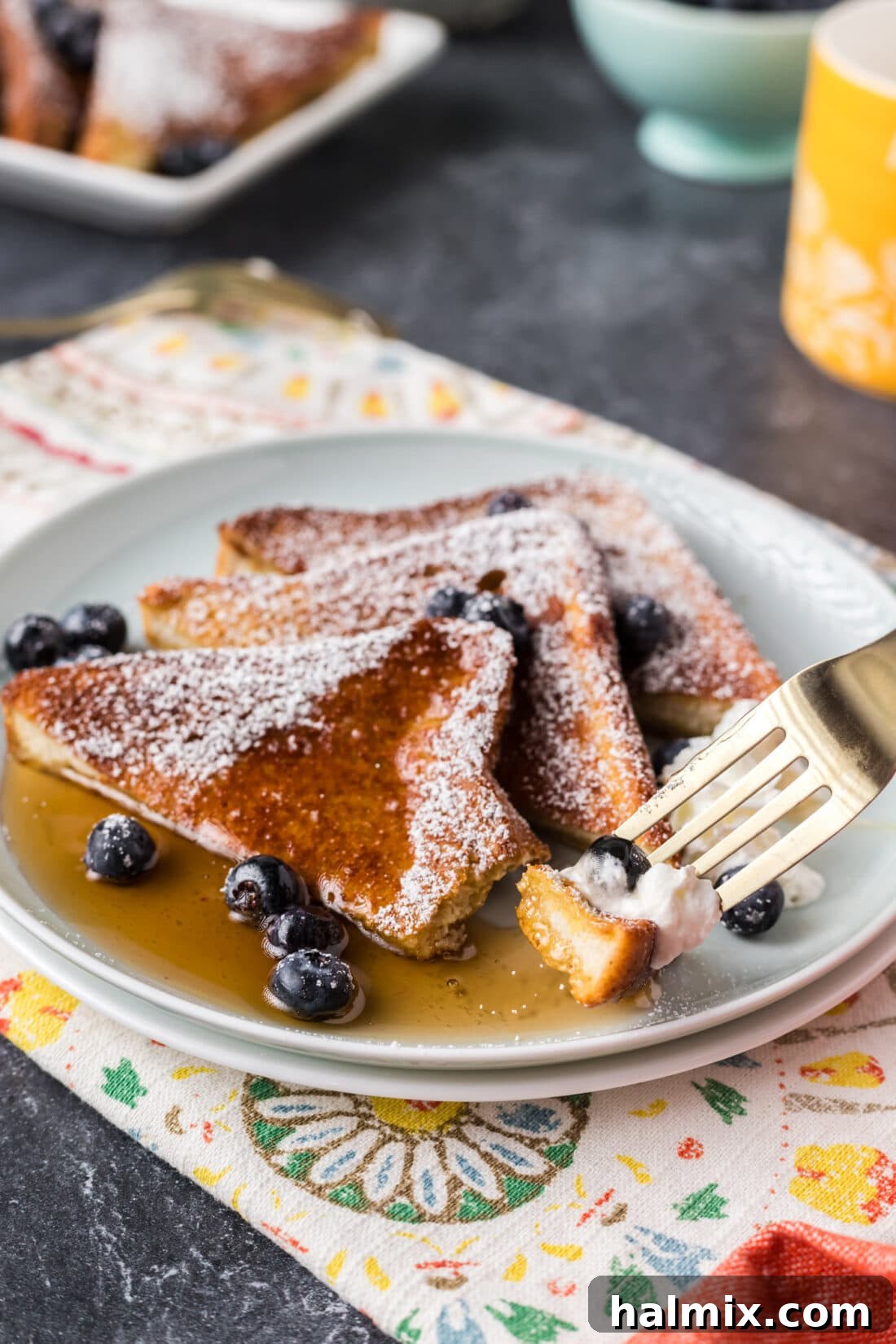 Piece of Air Fryer French Toast on a fork resting on a plate 