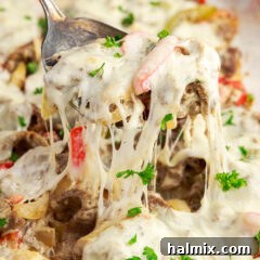 Spoonful of Philly Cheesesteak Casserole being lifted out of the pan