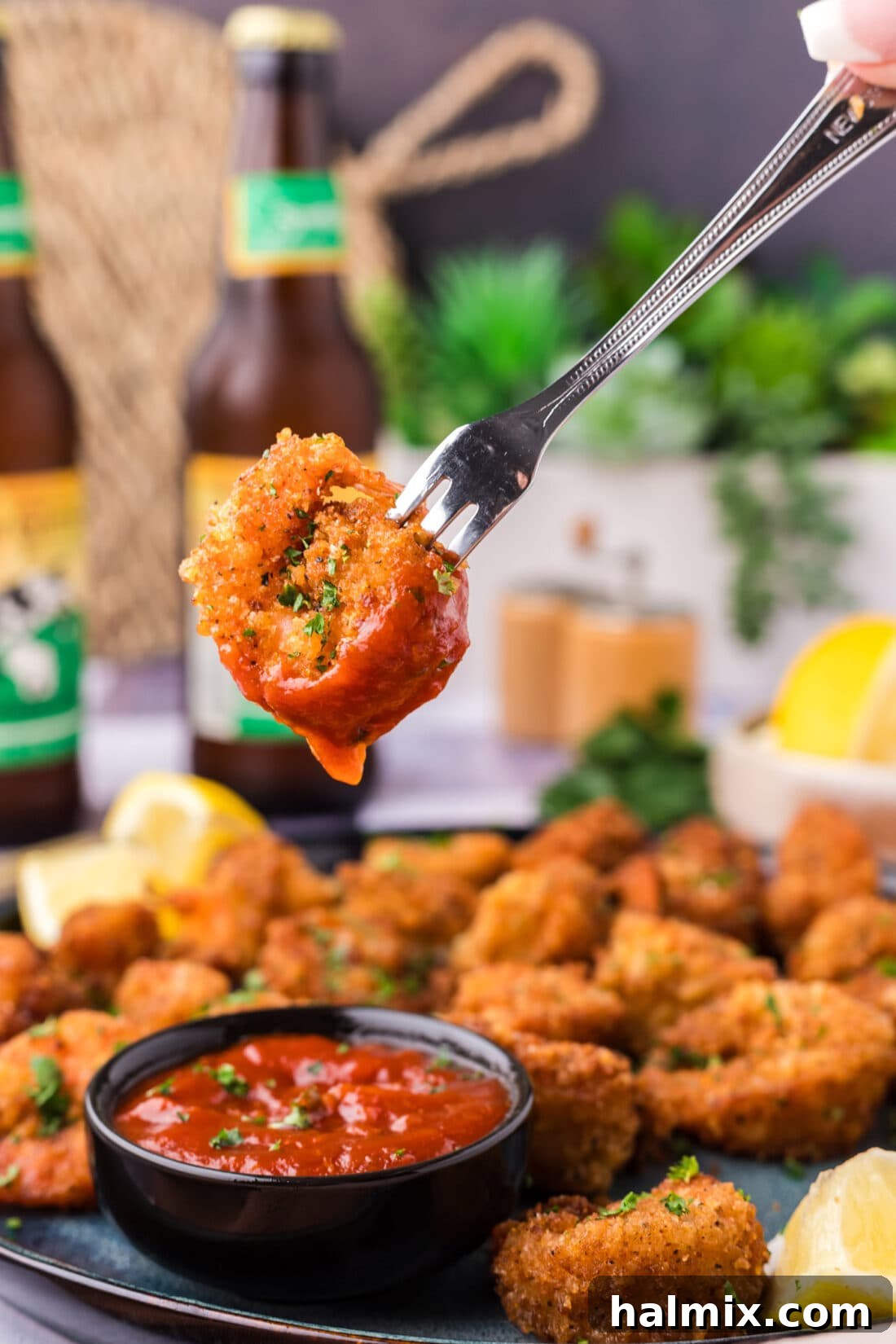 Breaded Shrimp dipped in cocktail sauce on a fork, showcasing its golden crispiness