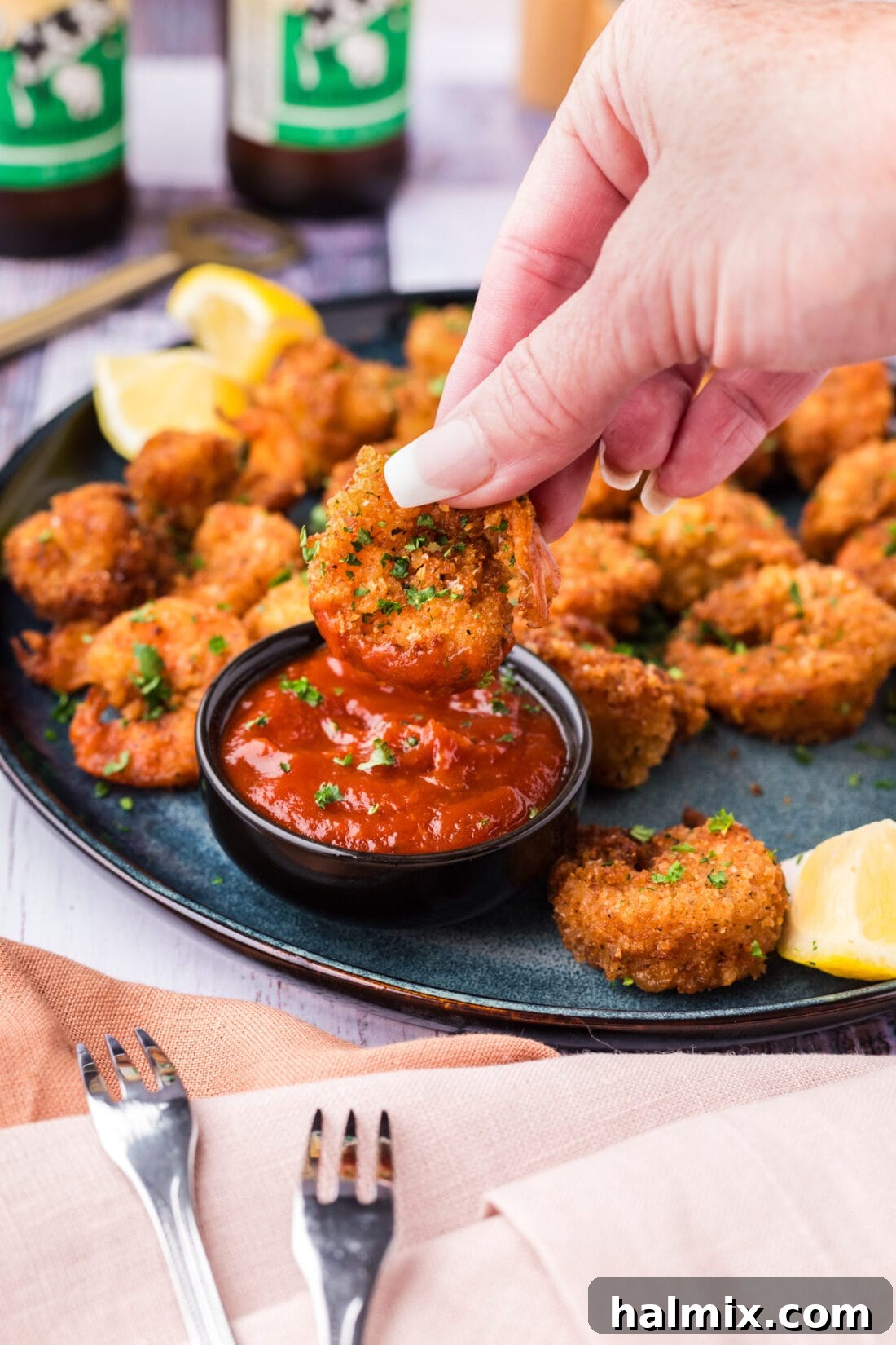Breaded Shrimp being dipped into a bowl of cocktail sauce, highlighting serving suggestions