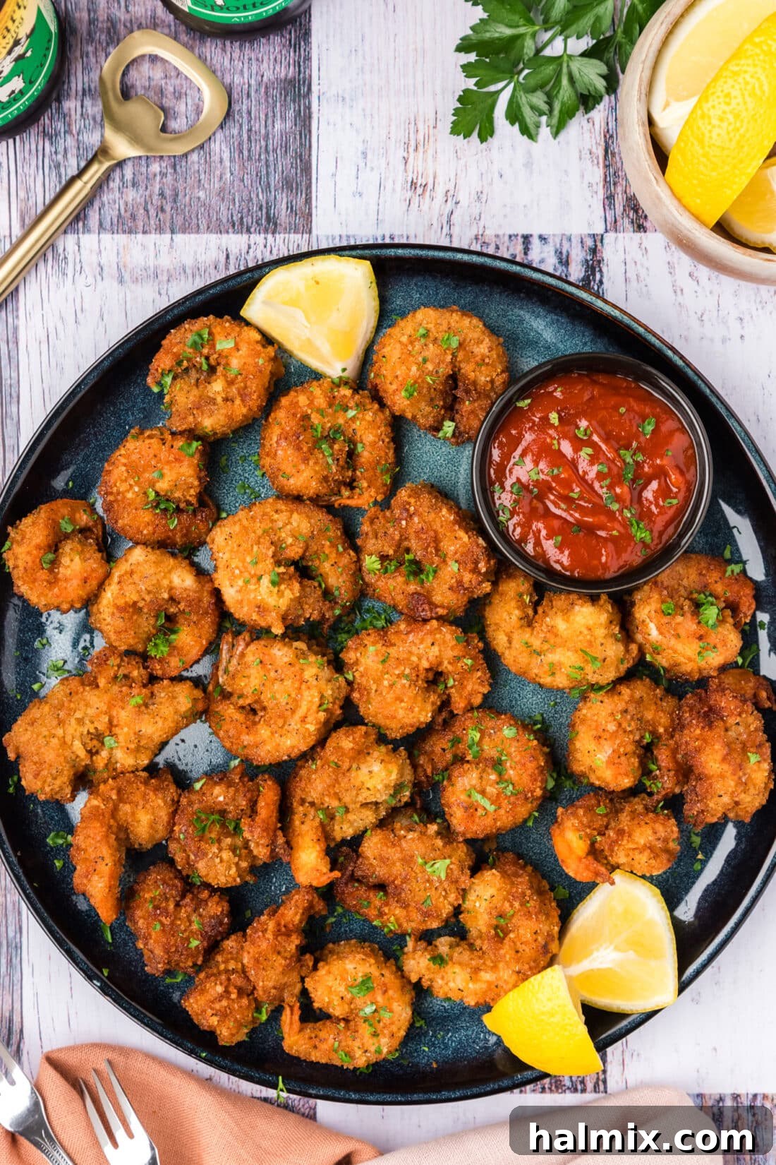 Plate of golden breaded shrimp with fresh lemon wedges, ready to be served