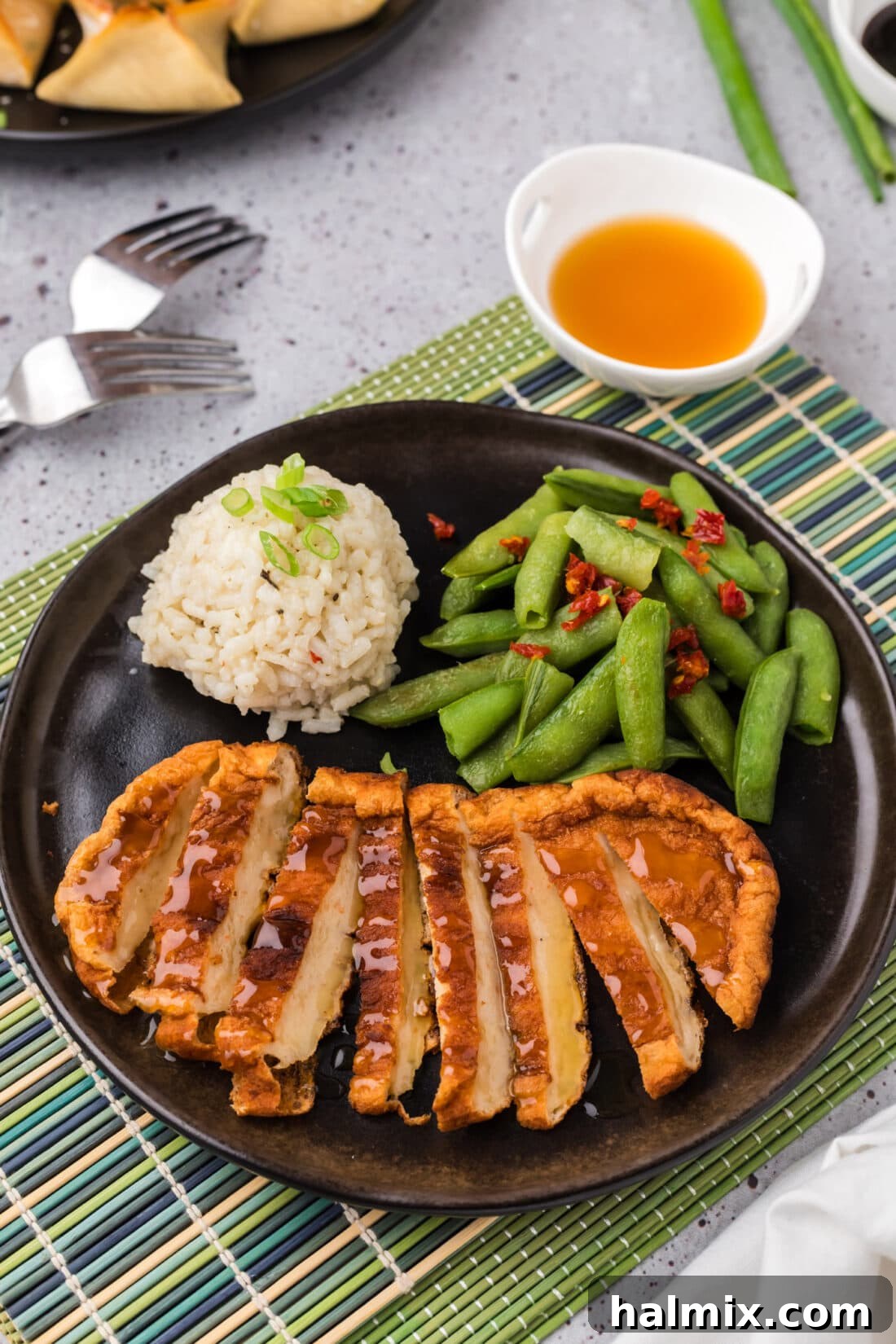 Korean Fish Cake sliced on a plate with rice and snap peas