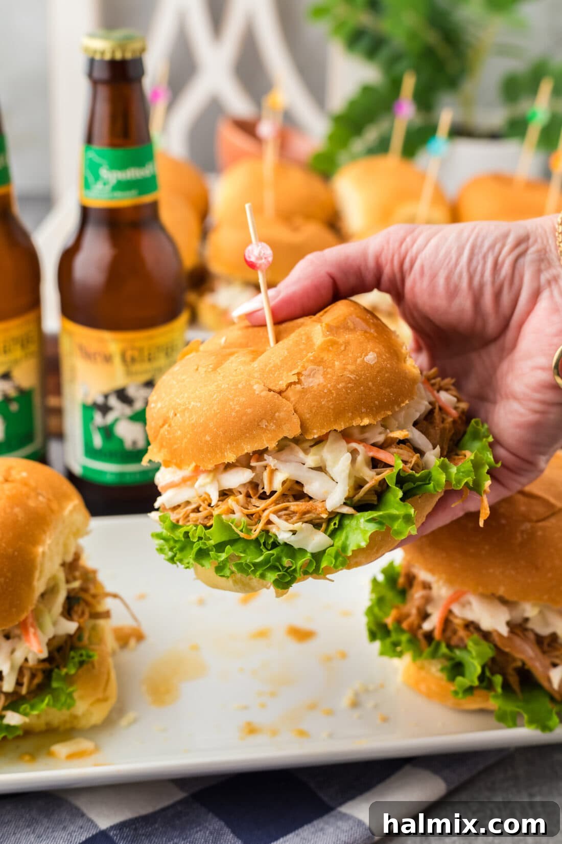 Hand holding up a perfectly crafted BBQ Chicken Sandwich, showcasing its delicious layers and toasted bun.