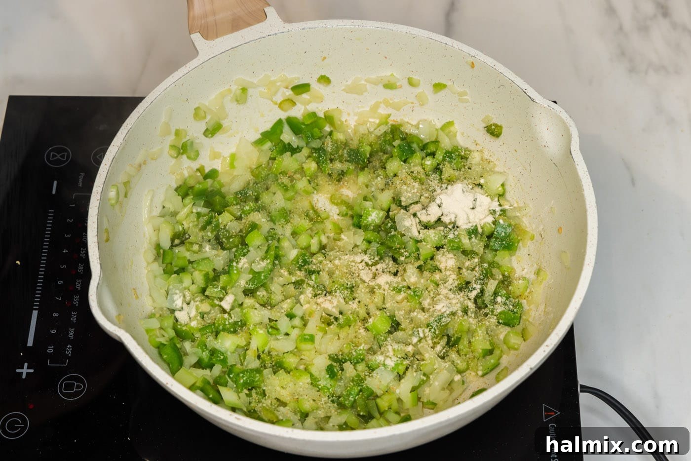 Adding garlic salt and onion powder to sautéed vegetables in a skillet