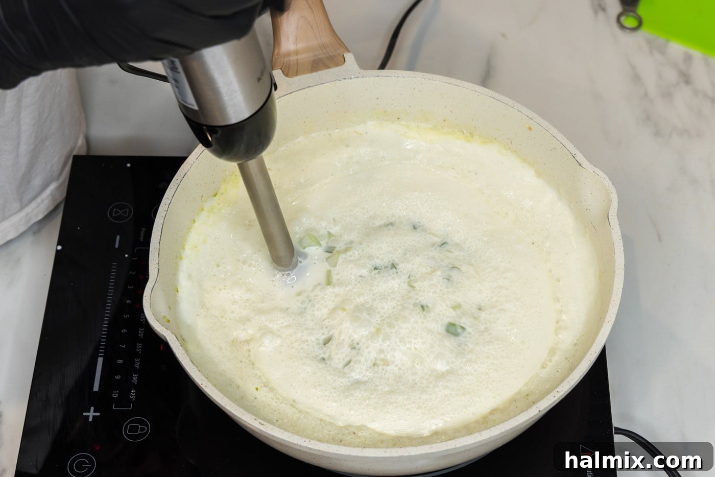 Using an immersion blender to smooth out sauce directly in a skillet