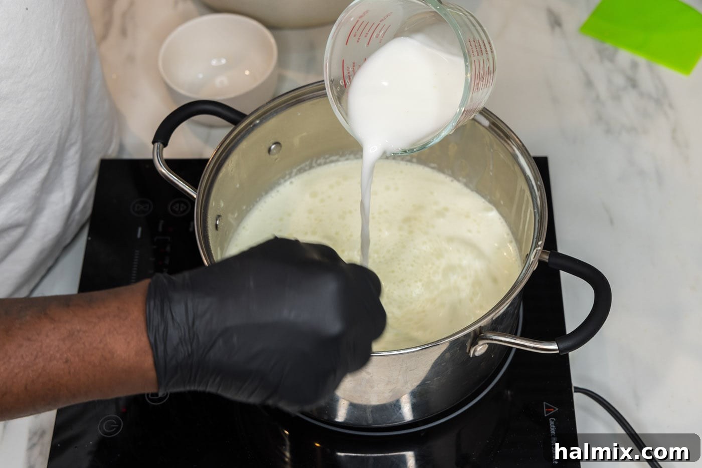 Whisking a cornstarch slurry into the simmering sauce to thicken it