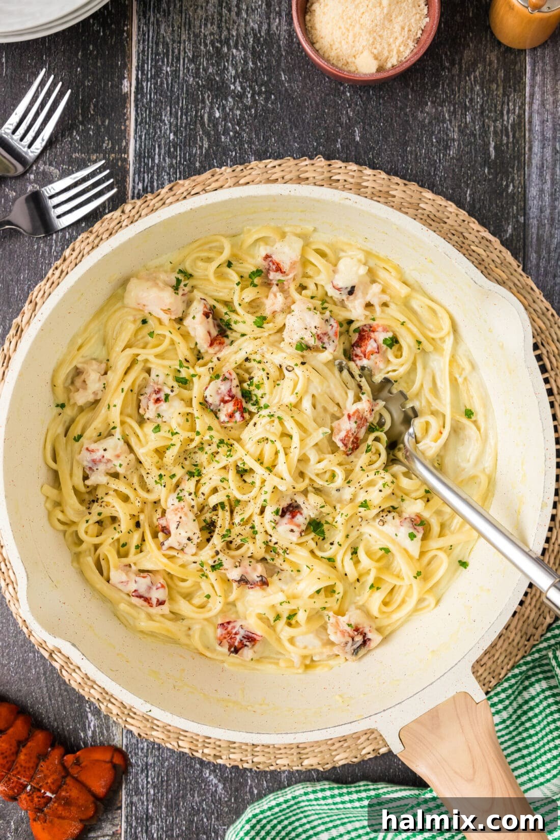 Overhead view of a skillet full of creamy lobster pasta, garnished with fresh parsley