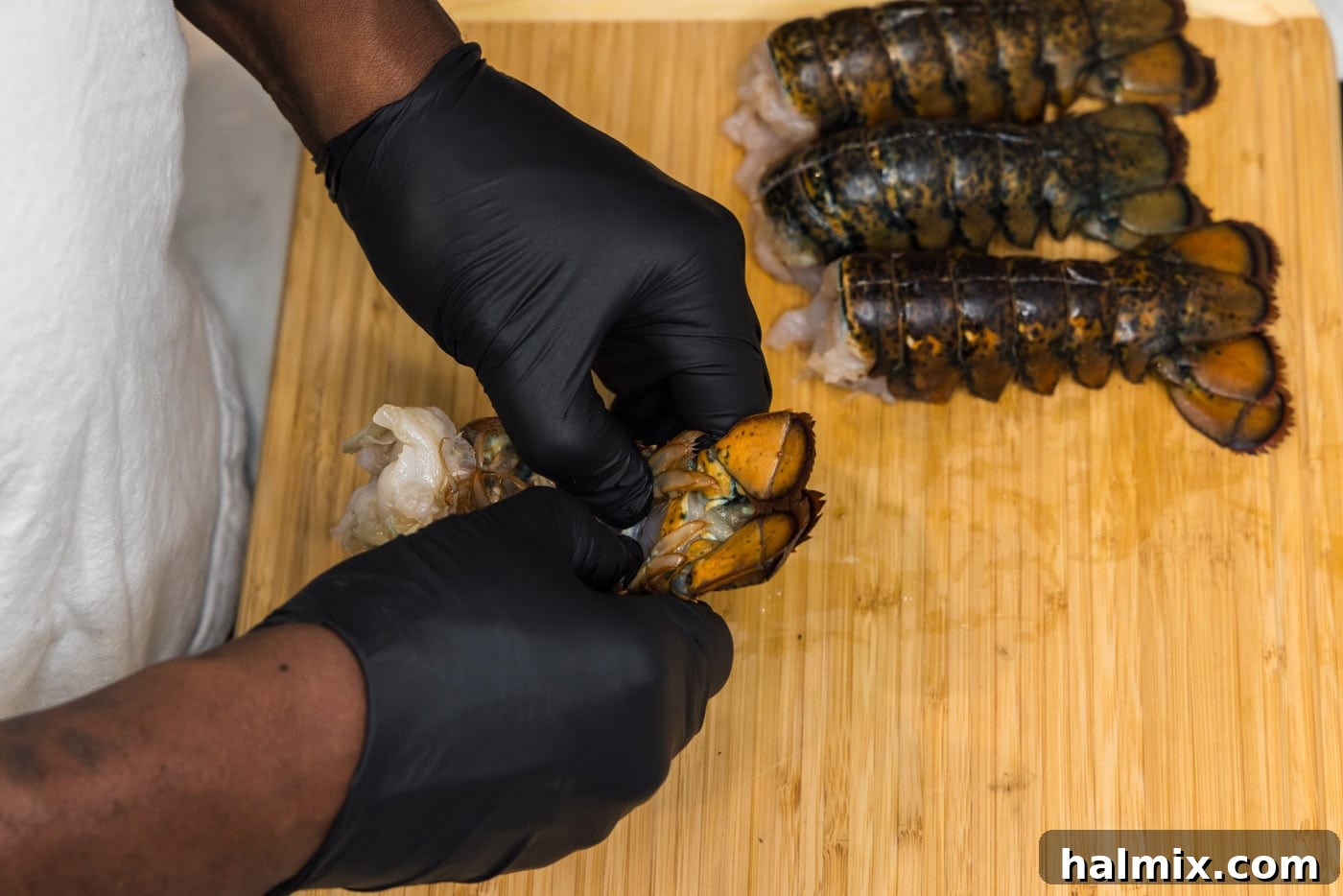 Opening a butterflied lobster shell to expose the raw meat