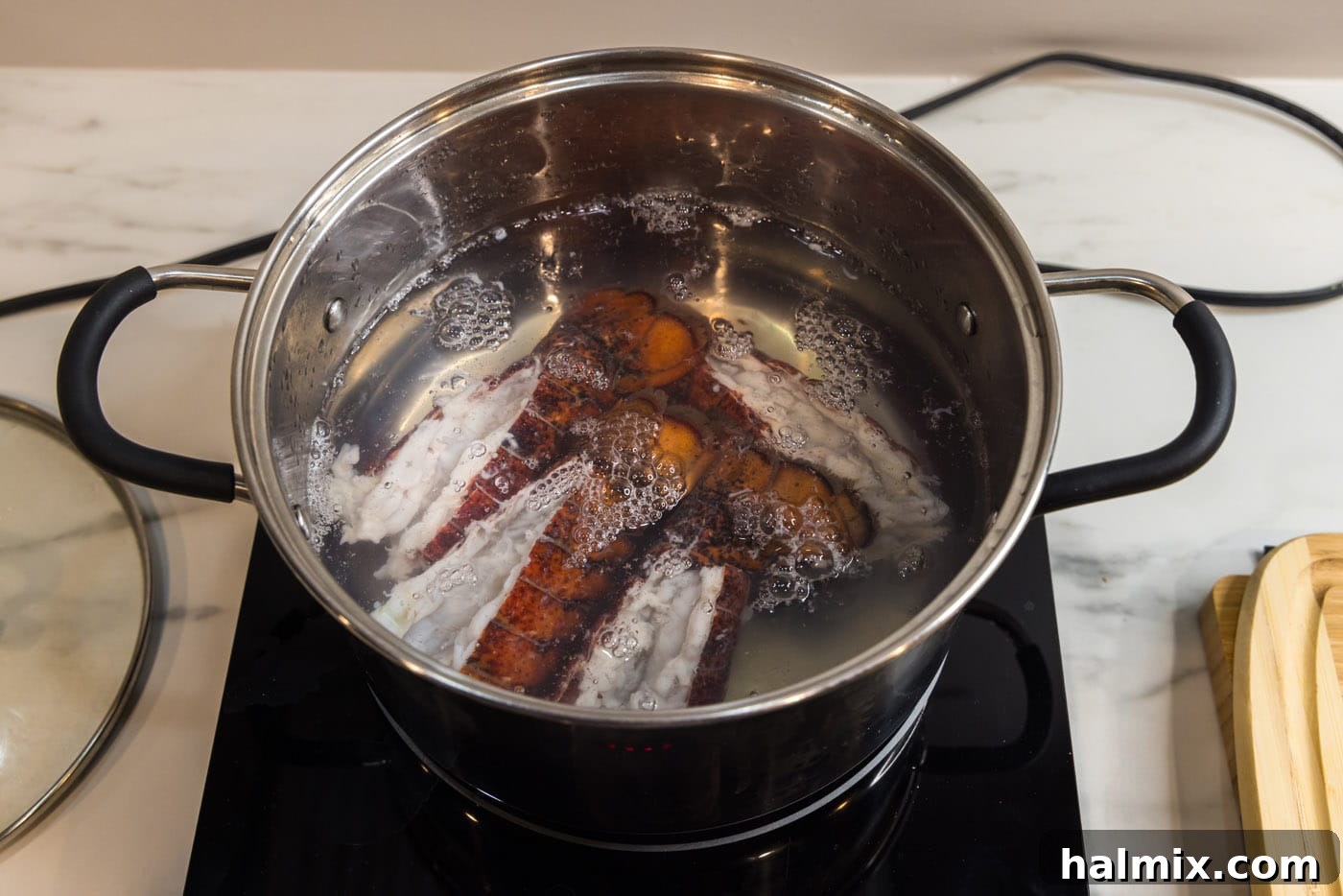Lobster tails cooking in a large stockpot of boiling water