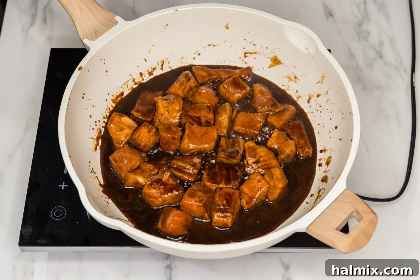 cooking salmon bites in marinde in a skillet