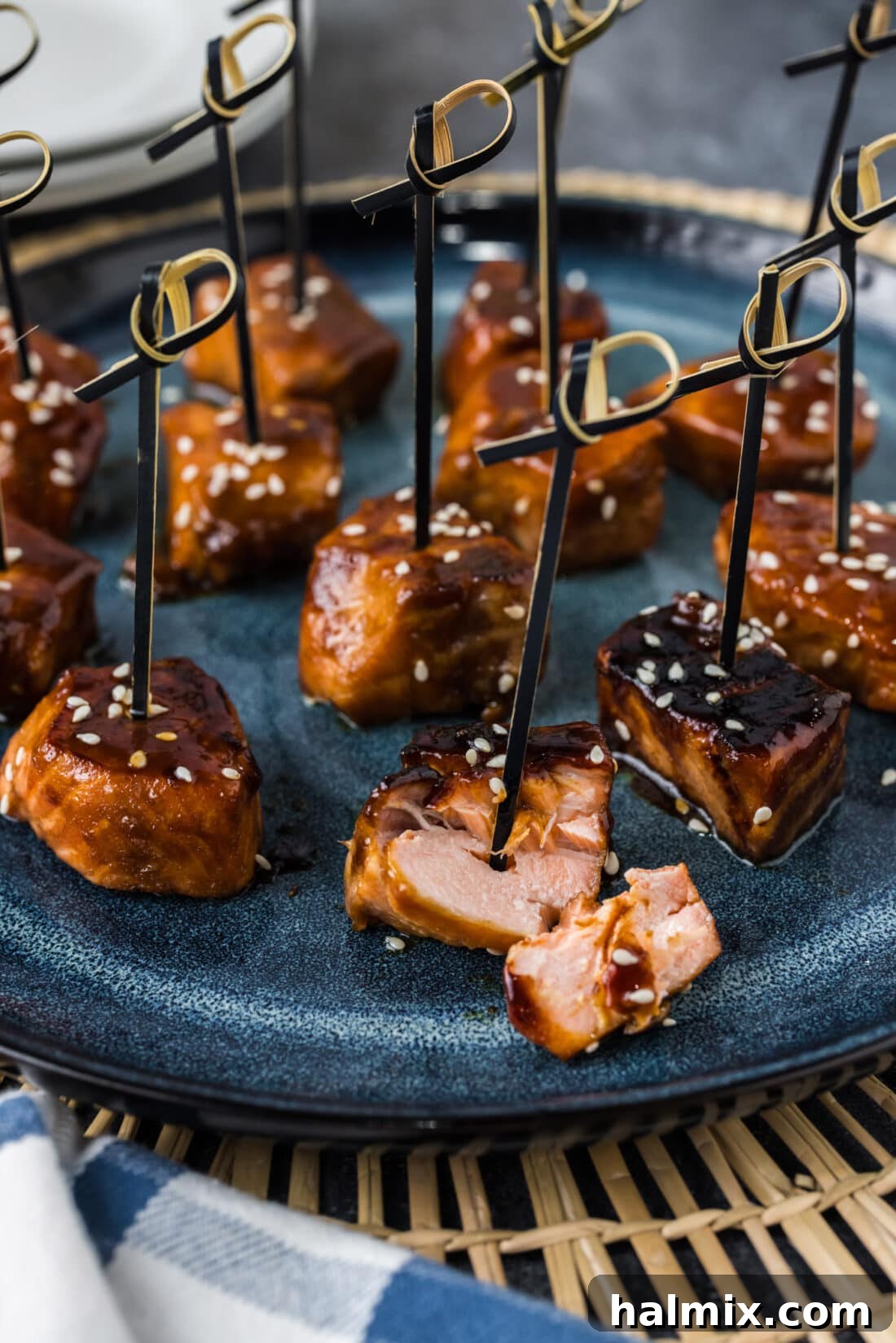 Salmon Bite broken apart on a plate with more Salmon Bites