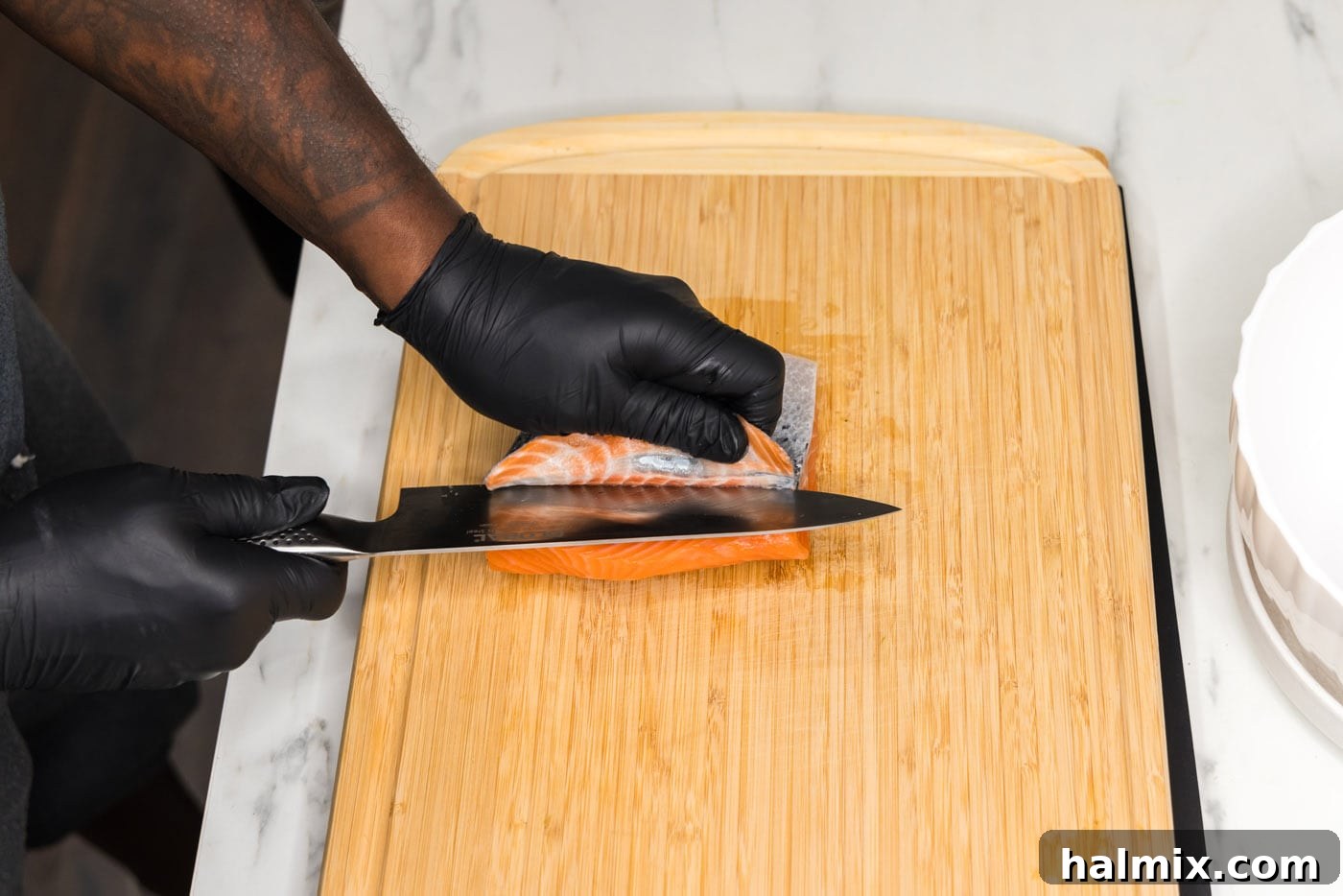 Removing skin from salmon filet with a knife