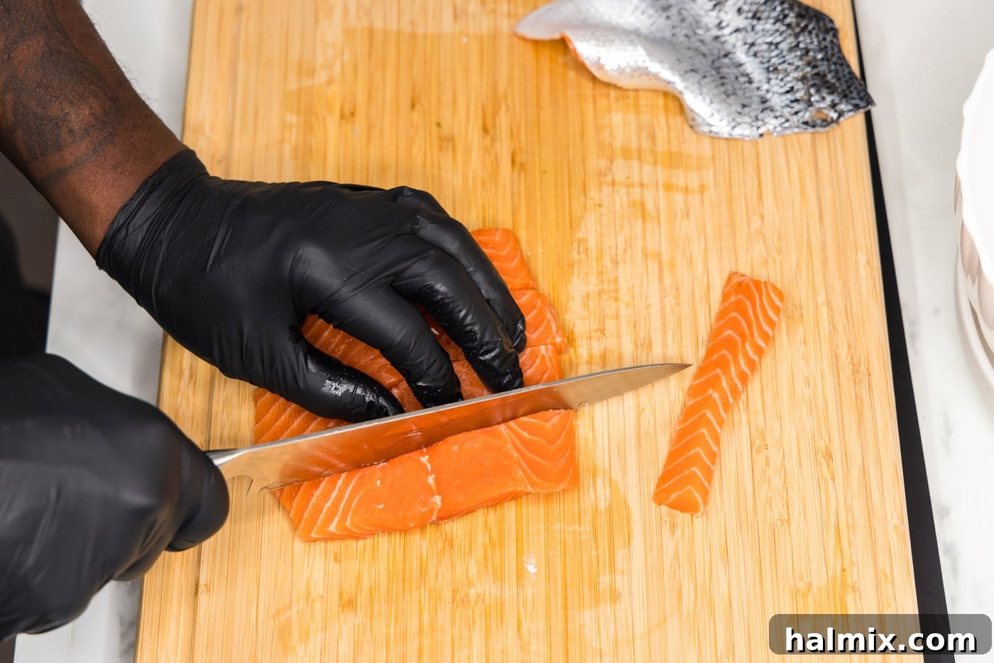 slicing salmon filet into strips