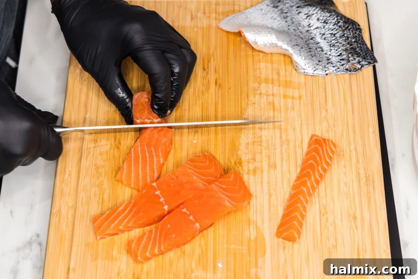 slicing salmon filet into cubes