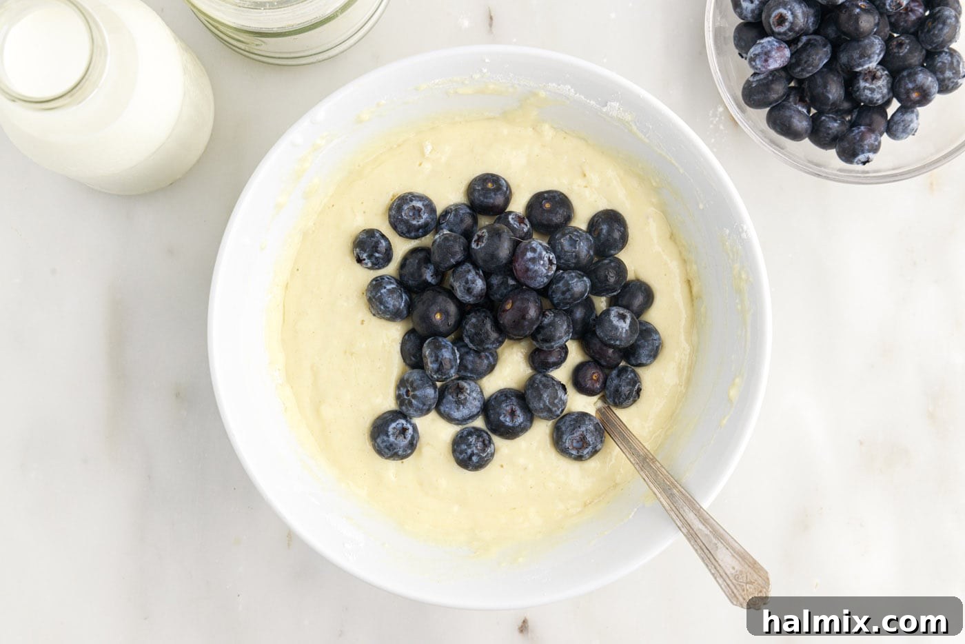 folding fresh blueberries into pancake batter