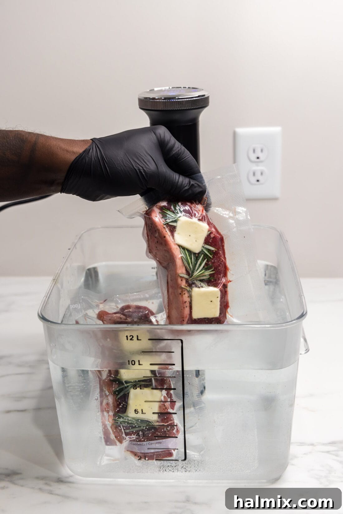 Sous Vide Steak being carefully lowered into the Sous Vide water container