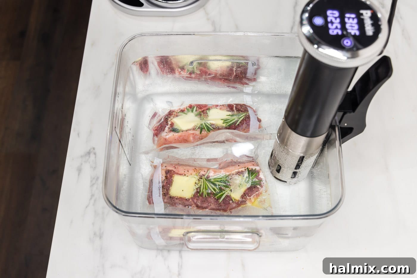 Vacuum-sealed New York strip steaks cooking in a sous vide water bath