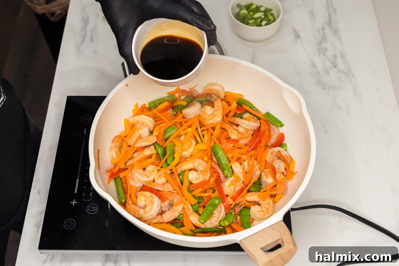 Sweet Chili Shrimp Stir-Fry 7 pouring soy sauce into skillet with shrimp stir fry