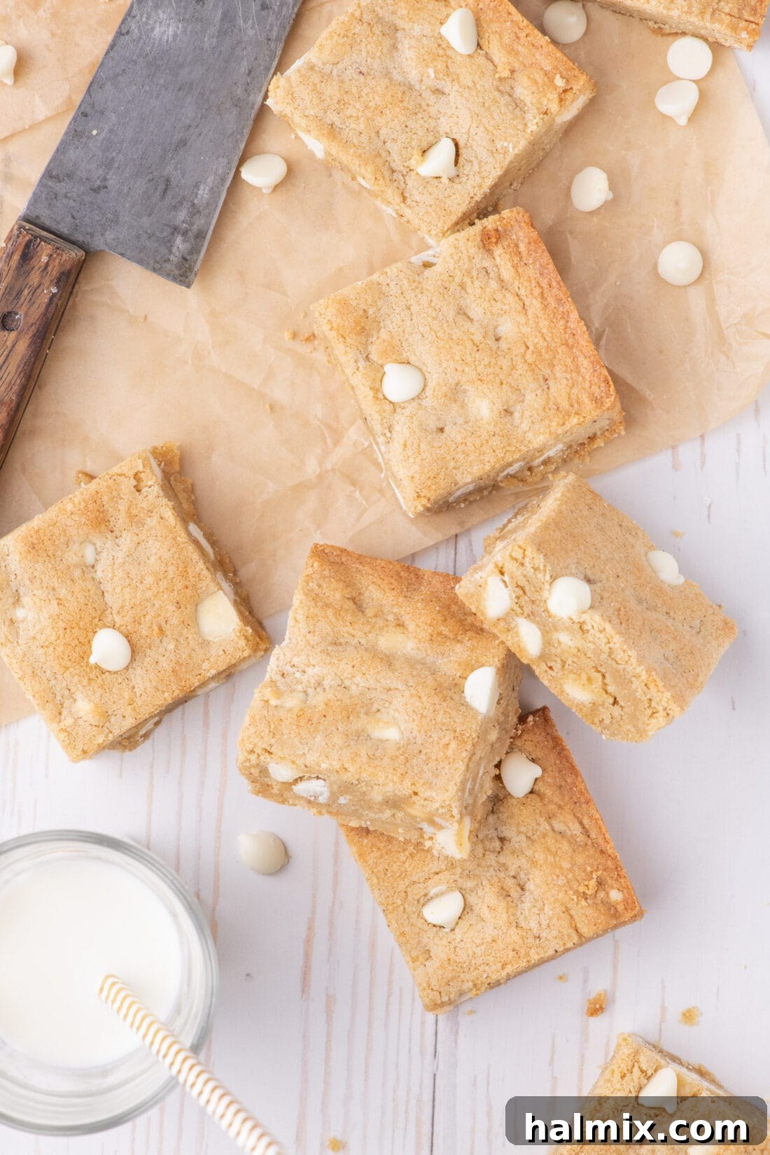 Golden Delights 3 Blondies resting on parchment paper with a glass of milk