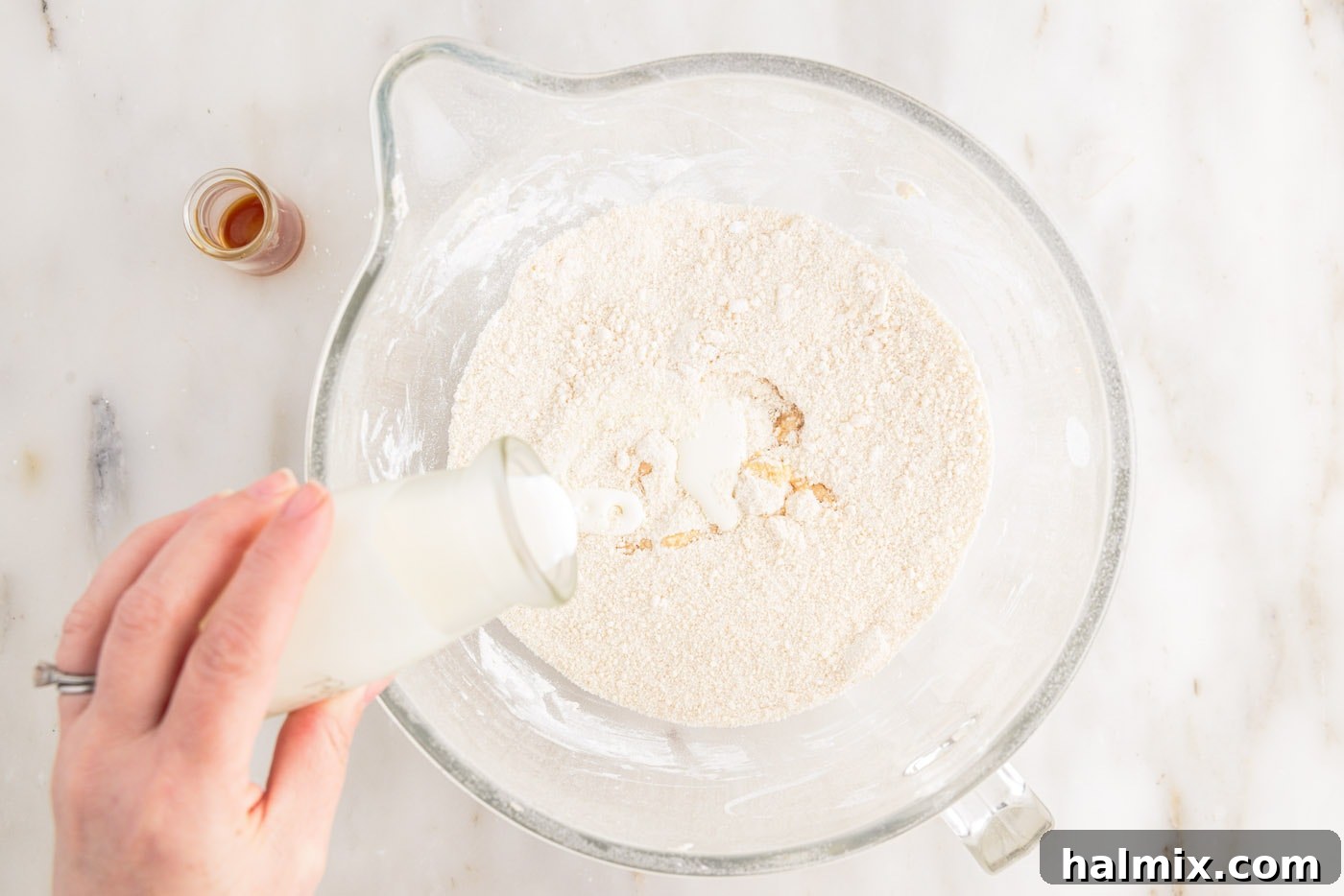 Brown Butter Cream Cheese Frosting 11 pouring heavy whipping cream to bowl of whipped brown butter and powdered sugar