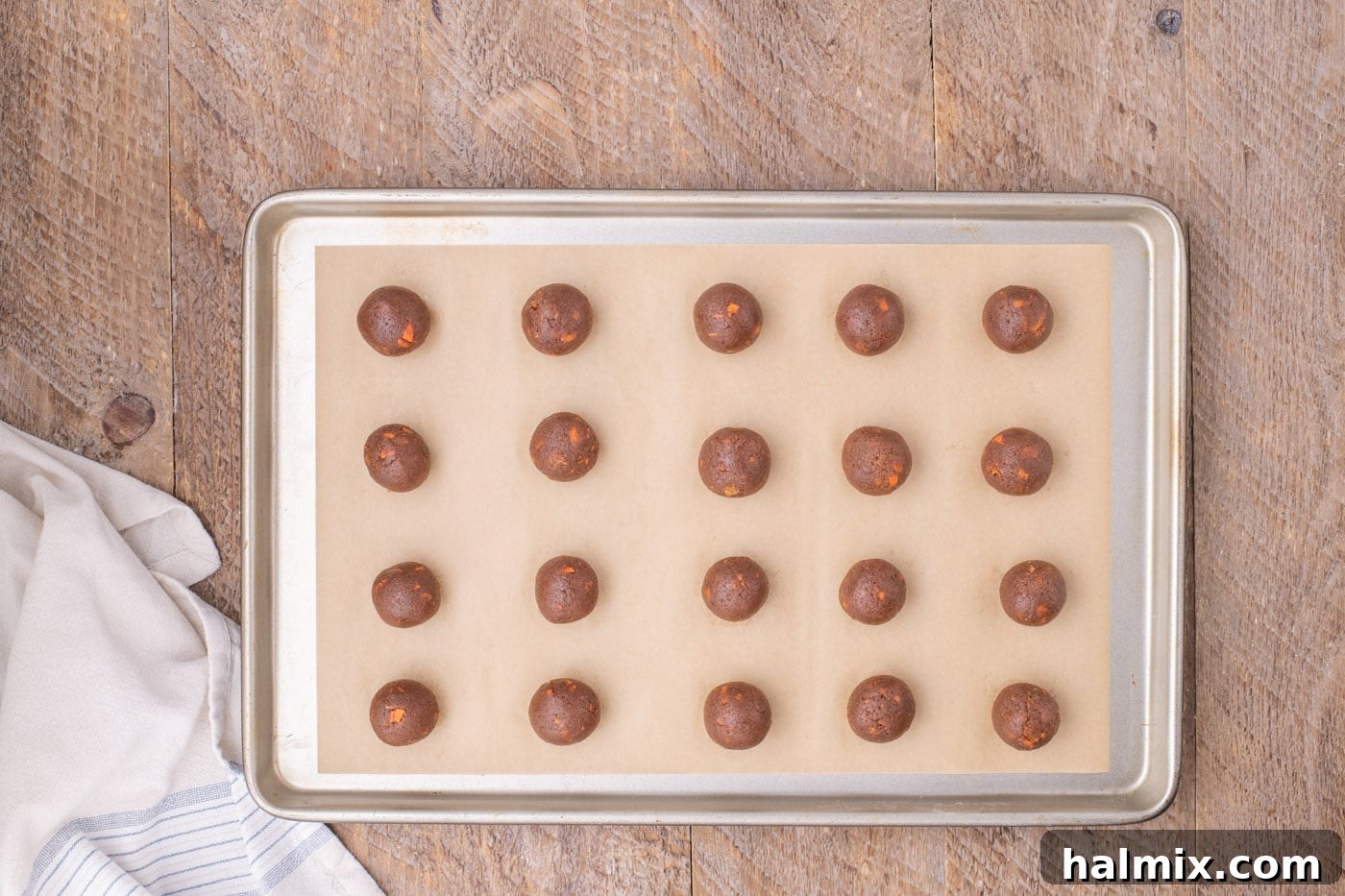 Chilled carrot cake balls neatly arranged on a parchment-lined baking sheet