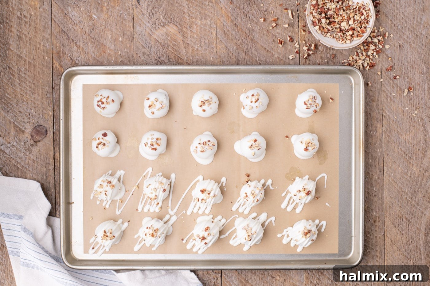 Finished carrot cake truffles, dipped in white chocolate and garnished, arranged on a baking sheet