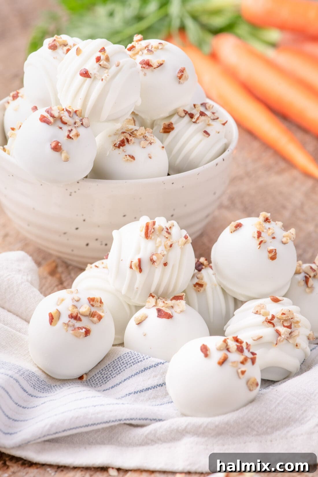 Carrot Cake Truffles beautifully arranged in a bowl, with some resting on a decorative towel