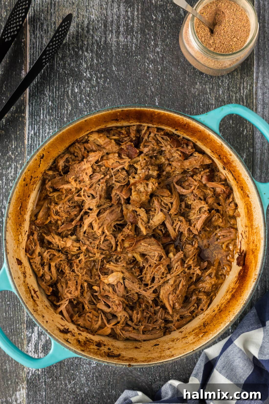 Pot of Pulled Pork in a Dutch oven with serving spoon