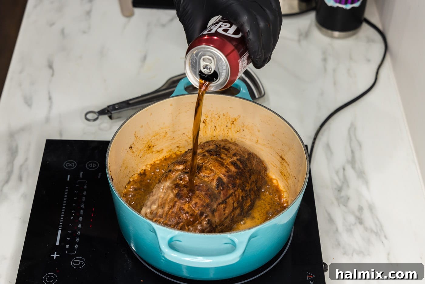 pouring dr pepper over seared pork shoulder in a dutch oven