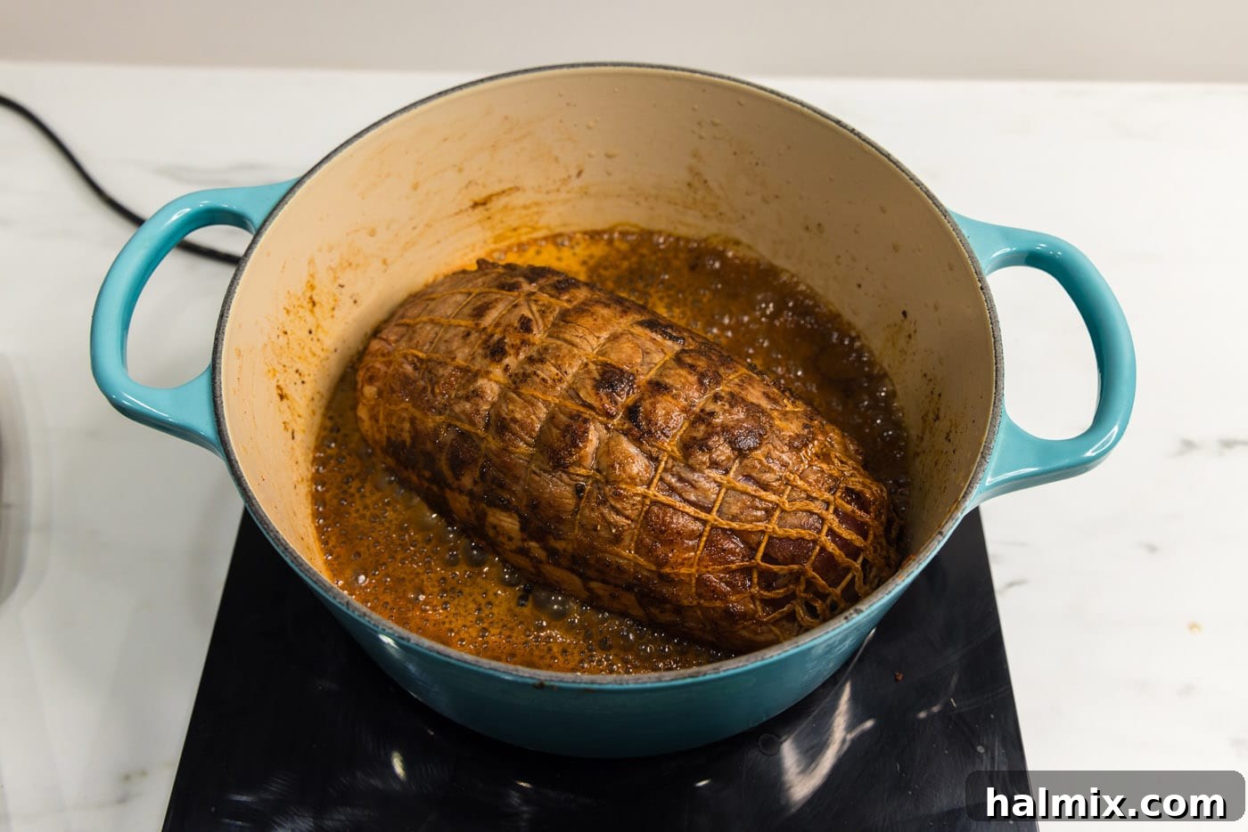 pork shoulder braising in a dutch oven with dr pepper in the oven