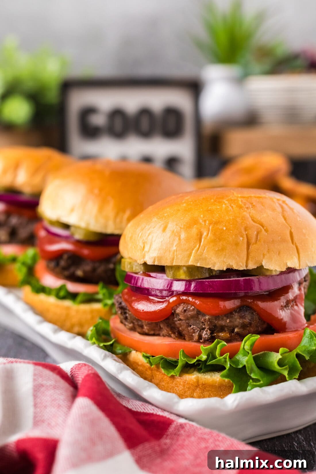 Three perfectly cooked air fryer burgers arranged on a platter, ready to be served with fresh toppings.