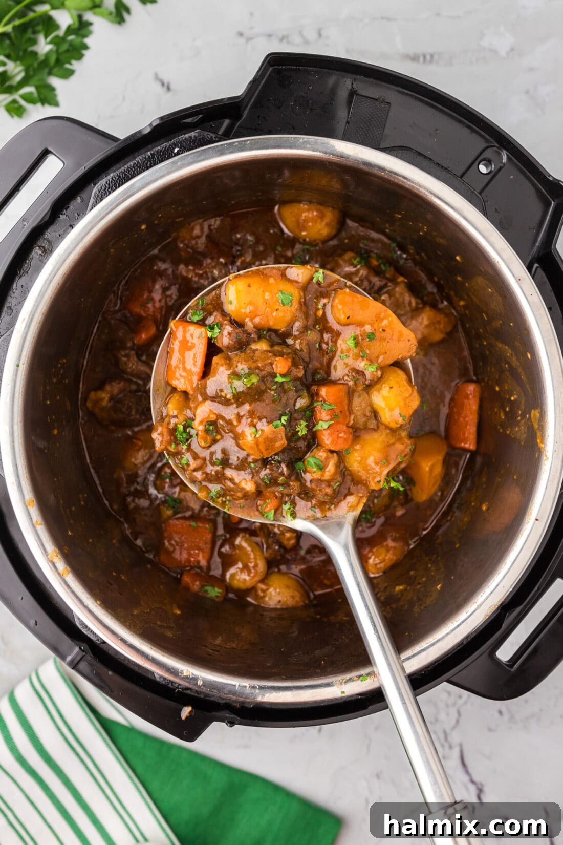 Serving spoon holding Instant Pot Oxtail over an Instant Pot
