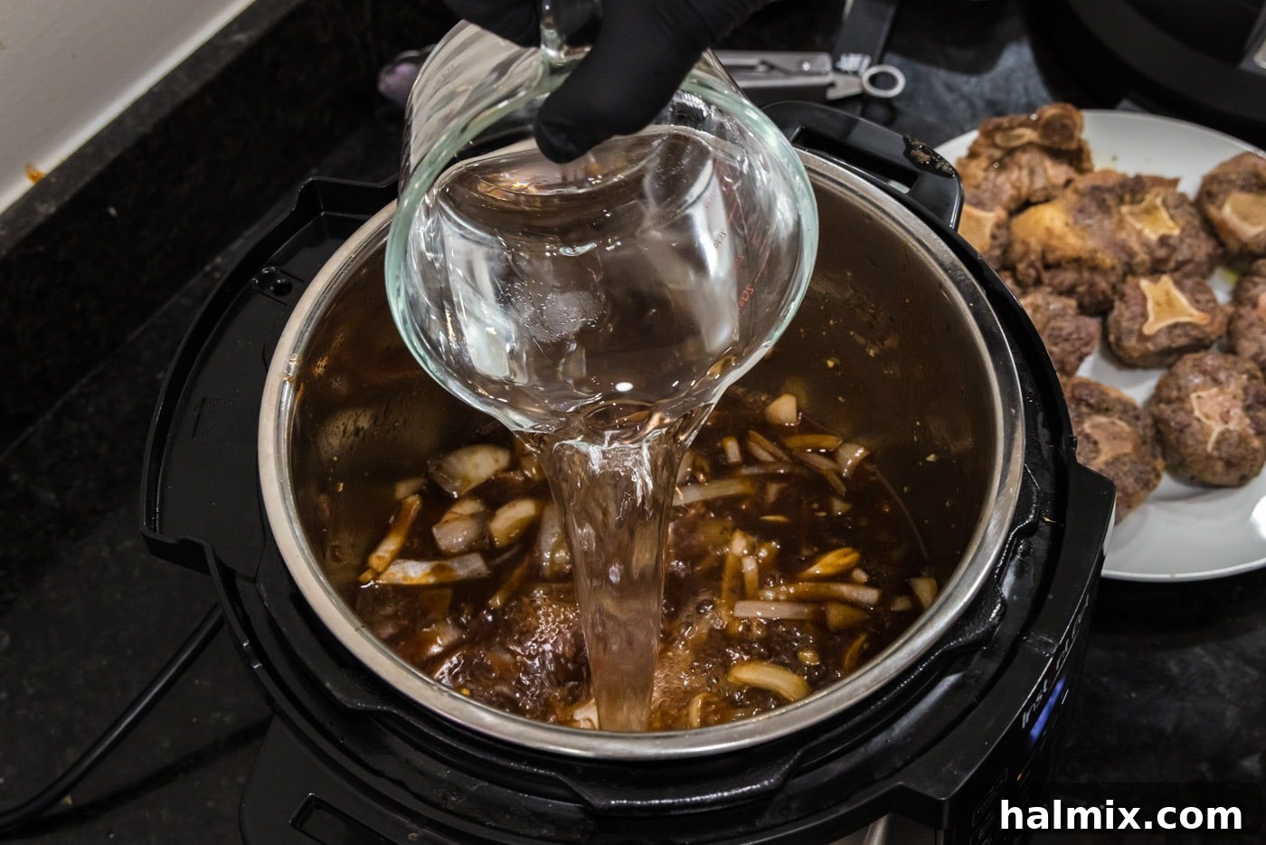 pouring water into instant pot oxtail stew