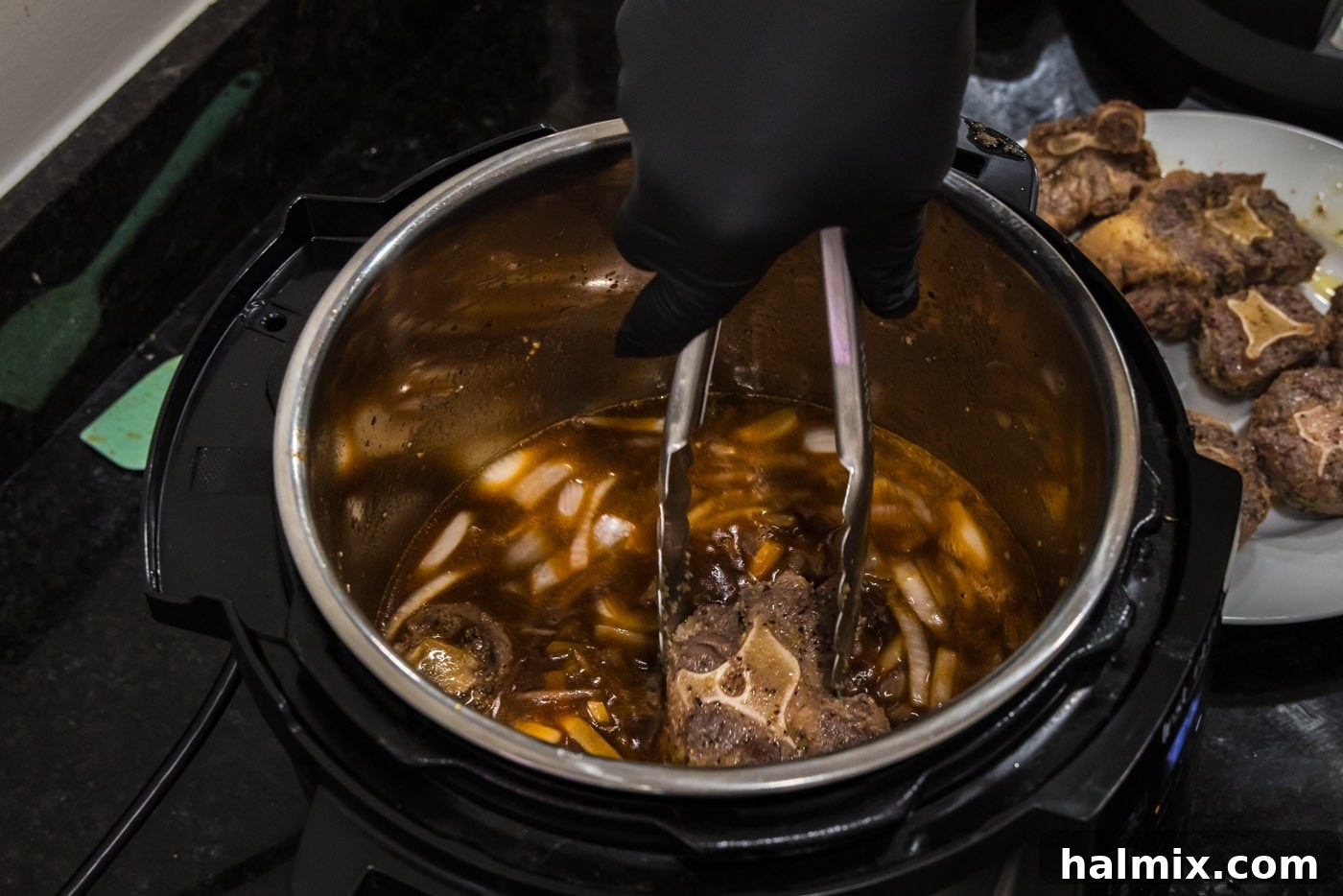 adding oxtail to sauce mixture in instant pot