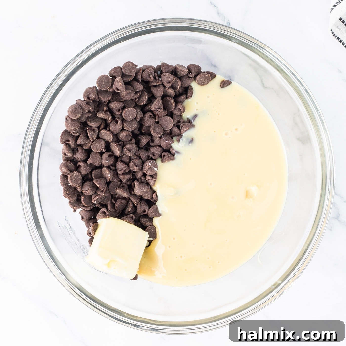 semi sweet chocolate chips in a bowl with butter and sweetened condensed milk