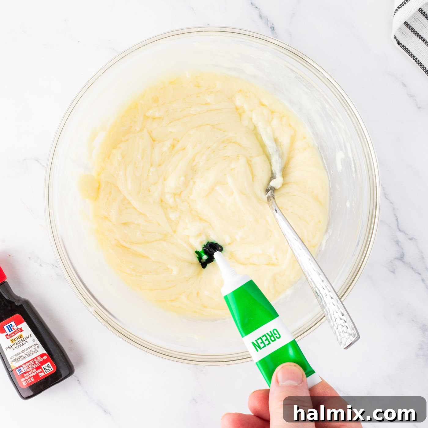 adding green food coloring and peppermint extract to white chocolate fudge