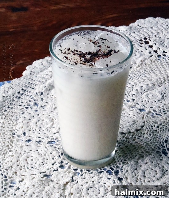 A tall clear glass filled with a creamy Olive Garden Italian cream soda copycat, garnished with rich chocolate shavings, ready to be sipped.