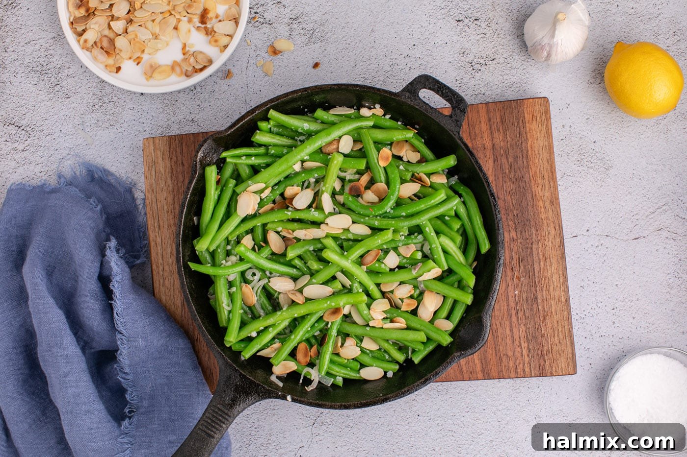 toasted almonds added to green beans in skillet