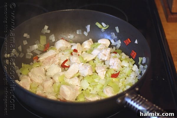 Hearty Chicken Chili with Black Beans and Sweet Corn 8 A close-up shot of cubed chicken, banana peppers, and onions browning to a golden perfection in a skillet.