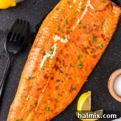 Smoked Trout on a board with lemons and a fork to the side