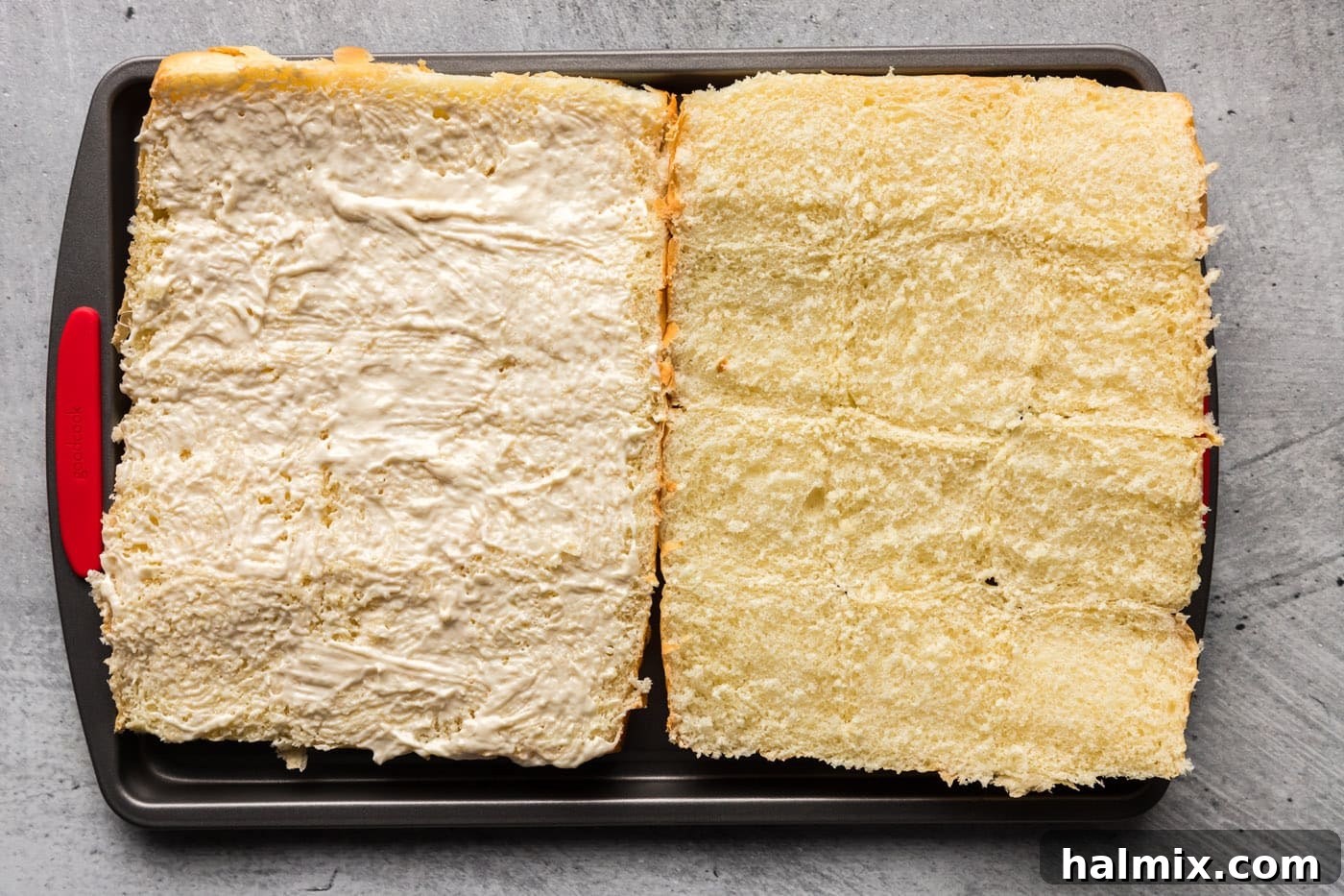 Horseradish mayo spread evenly on the bottom half of Hawaiian rolls, ready for layering
