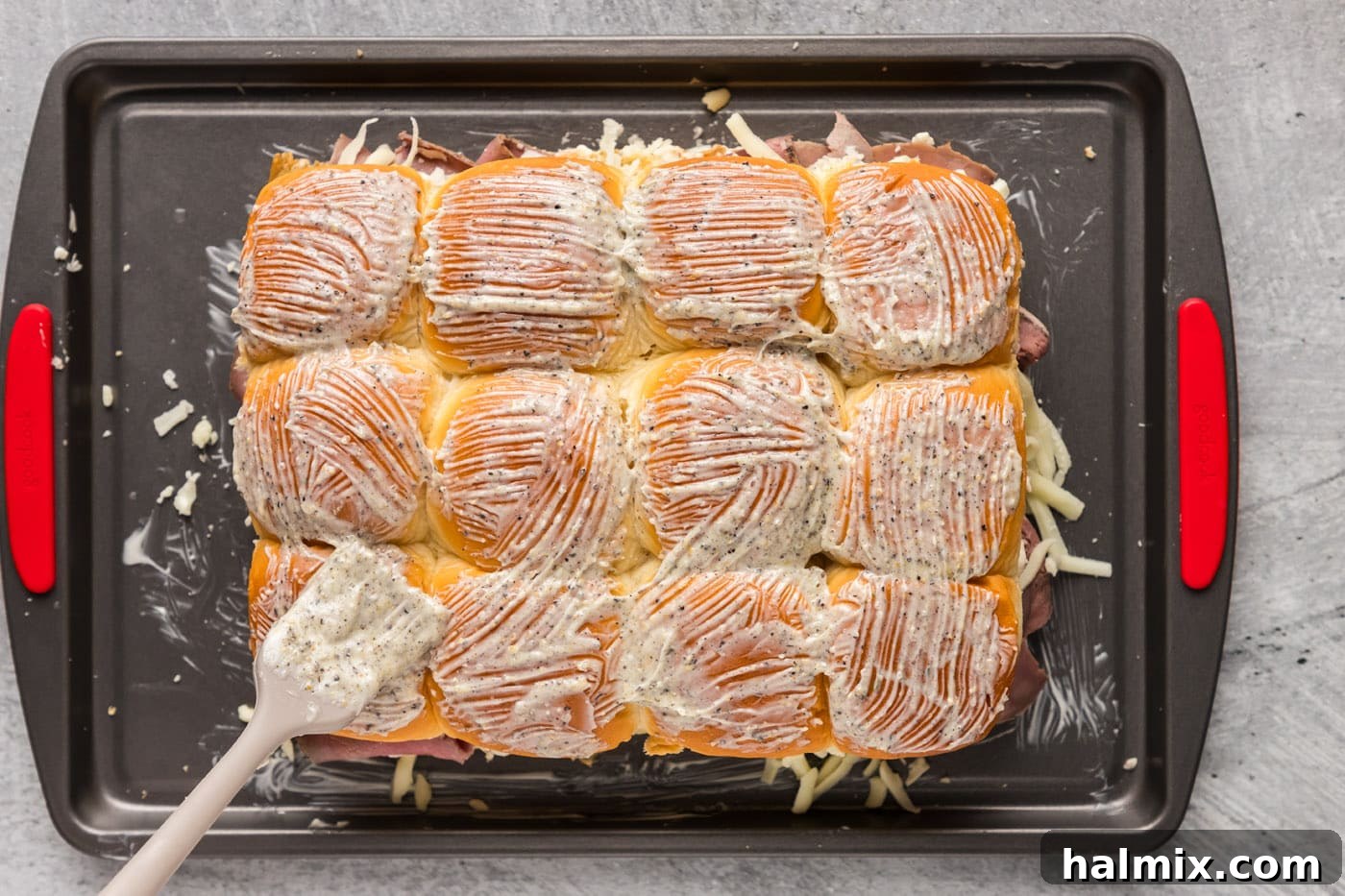 Basting slider buns with a fragrant garlic butter mixture before baking