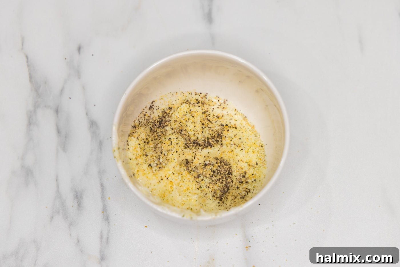 Golden Broiled Scallops 6 Mixing softened butter with garlic salt and pepper in a bowl.