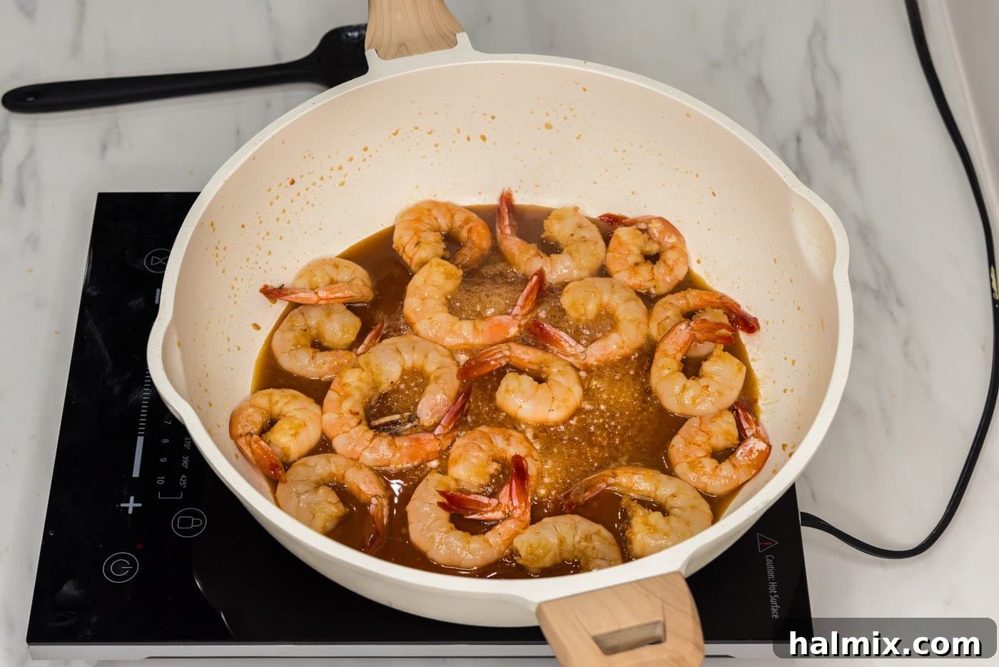 Golden Honey Garlic Shrimp 8 cooked shrimp in skillet with honey garlic sauce, ready for thickening