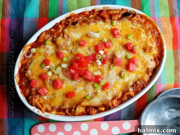 A freshly baked Chicken Tostada Casserole, bubbling hot and garnished with fresh green onions and tomatoes.