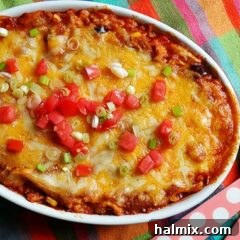 A top-down view of the Chicken Tostada Casserole, showcasing its rich, melted cheese and fresh garnishes.