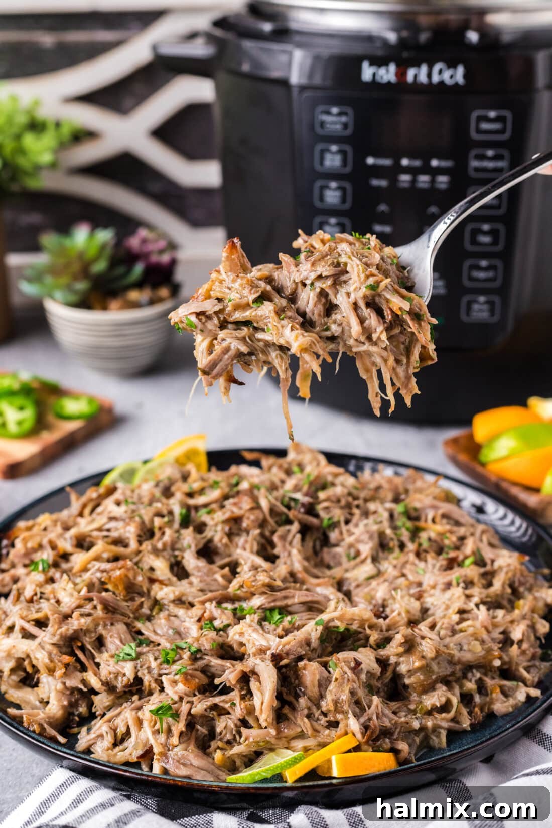 Crispy Instant Pot Carnitas 2 Forkful of Instant Pot Carnitas held above a plate of Instant Pot Carnitas