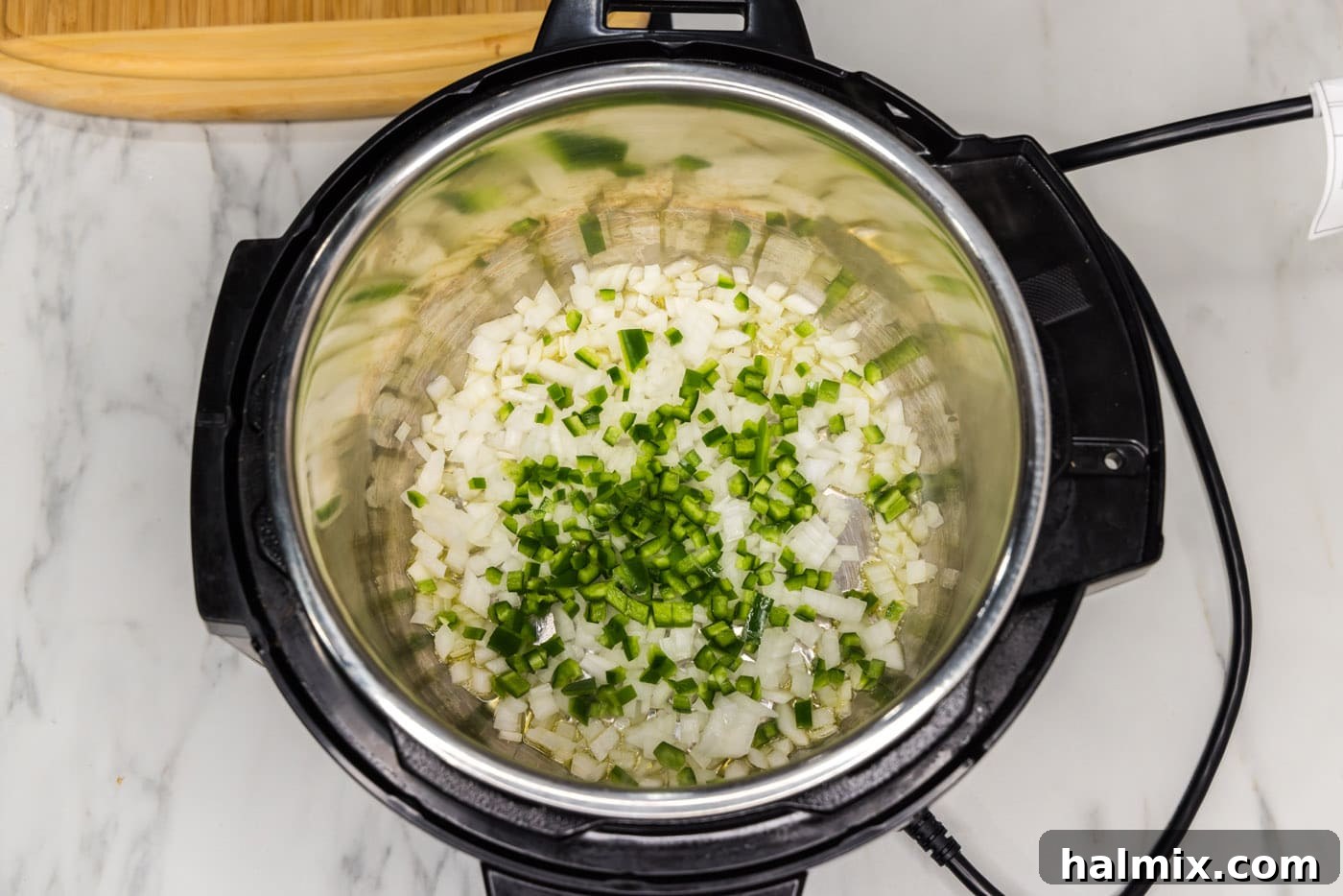 Crispy Instant Pot Carnitas 8 sauteeing jalapeno and onion in an instant pot