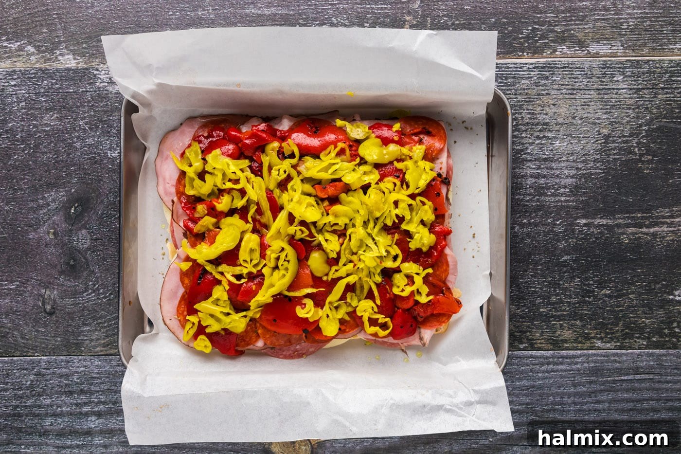 Sliced pepperoncinis on top of roasted bell peppers on Italian sliders for a tangy kick.