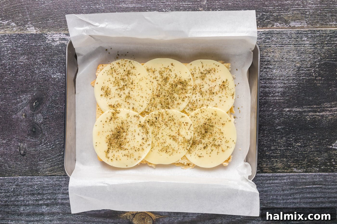 First layer of provolone cheese with Italian seasoning on slider buns.